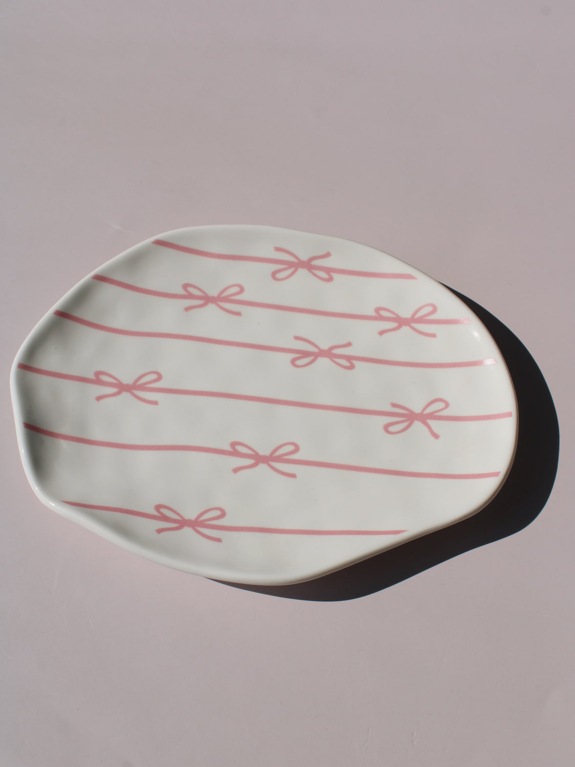 Lina Ceramic Plate with pink bow and ribbon line pattern, organic-shaped handmade ceramic plate top view
