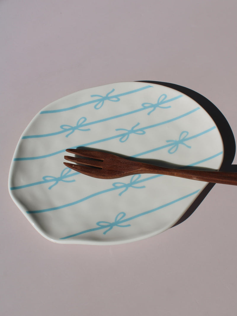 Rina Ceramic Plate with blue bow and ribbon line pattern, organic-shaped handmade ceramic plate top view