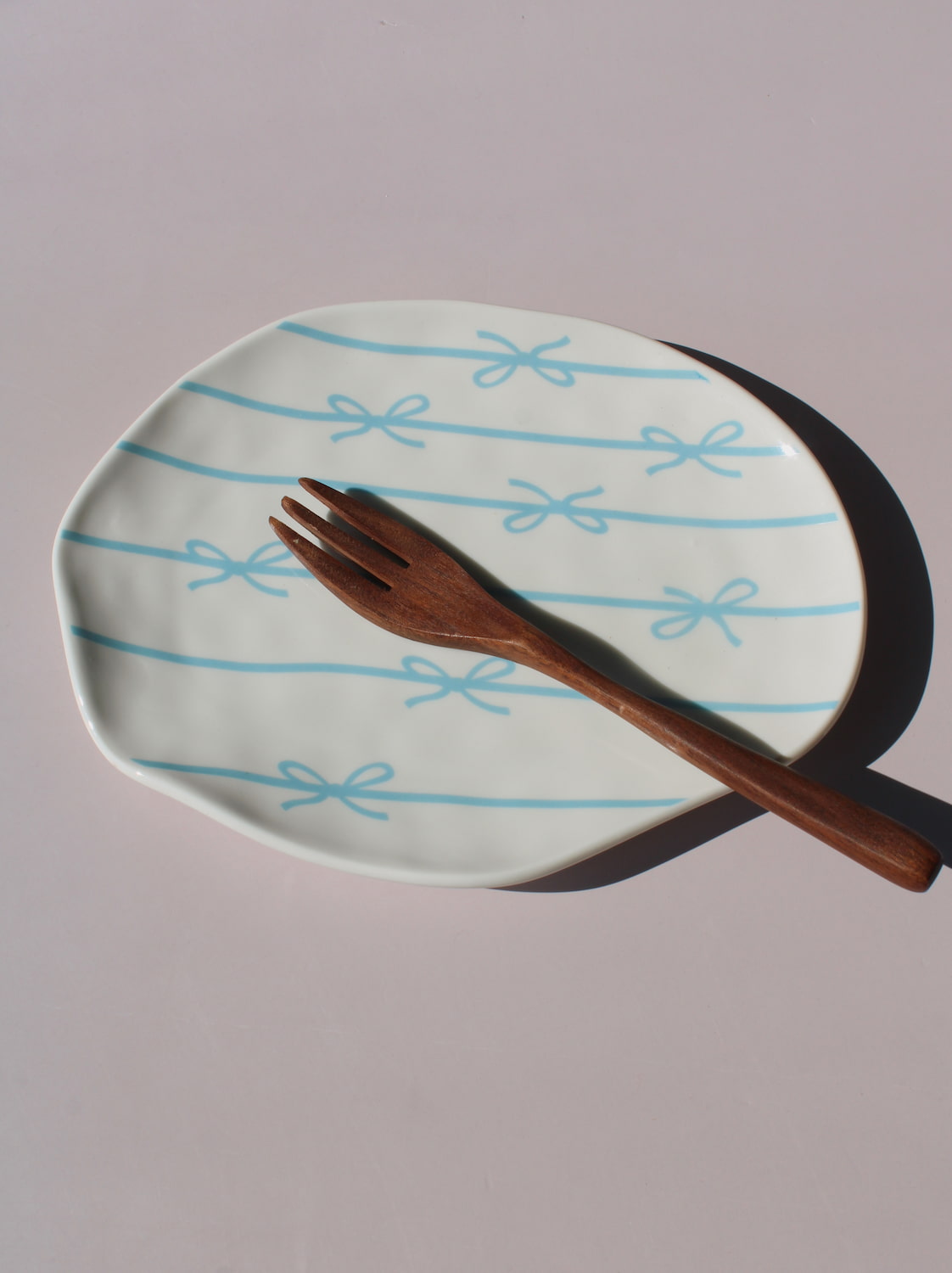 Rina Ceramic Plate with blue bow and ribbon line pattern, organic-shaped handmade ceramic plate top view