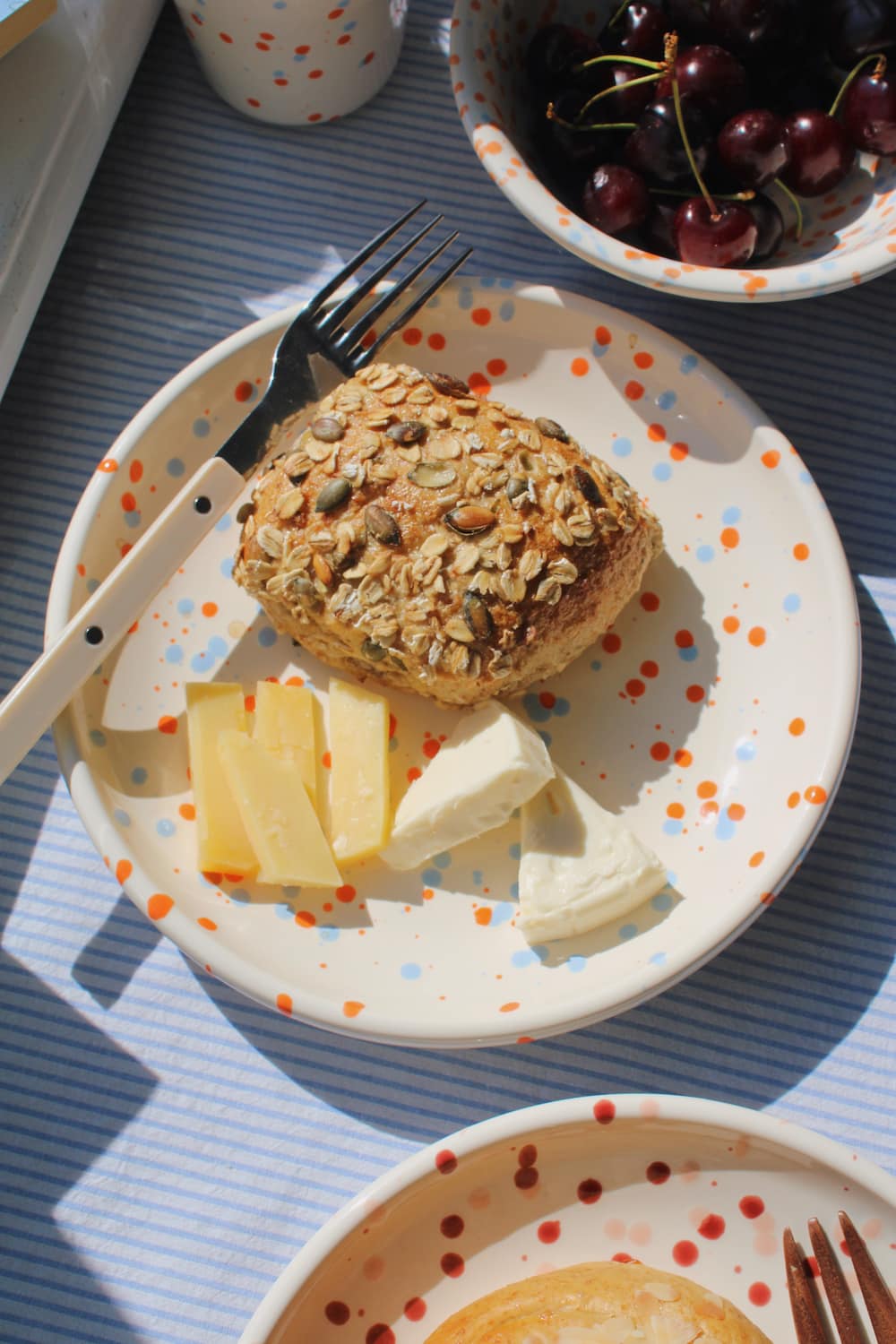 Naro Ceramic Plate styled with a seeded bread roll and cheese