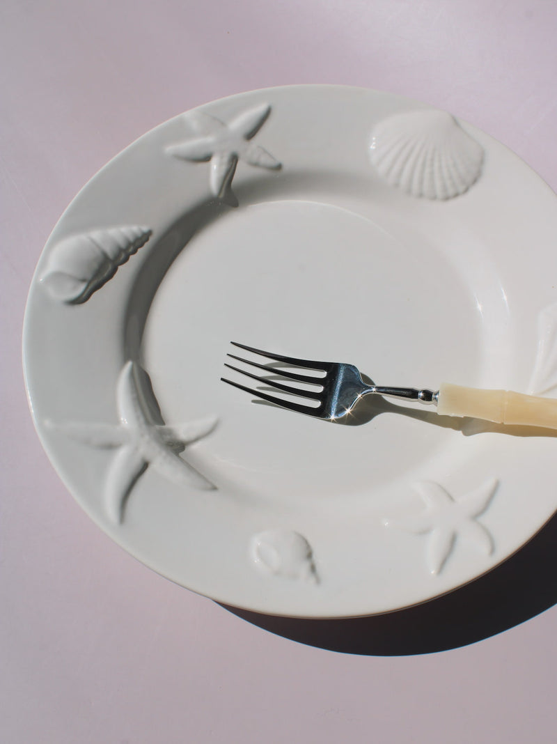 Caspia Ceramic Plate with embossed starfish, seashells and conch border, white ceramic dinner plate top view