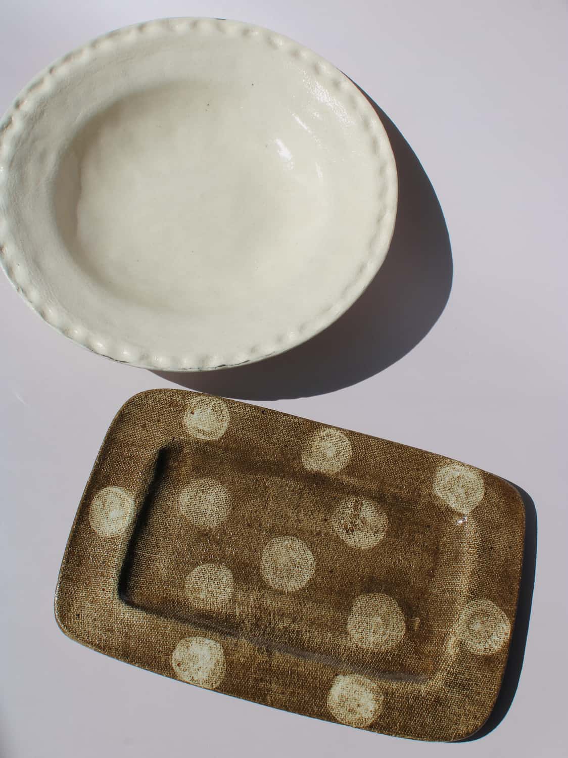 Lunette Ceramic Plate paired with Biscotti Ceramic Plate, cream scalloped plate beside brown polka dot rectangular tray