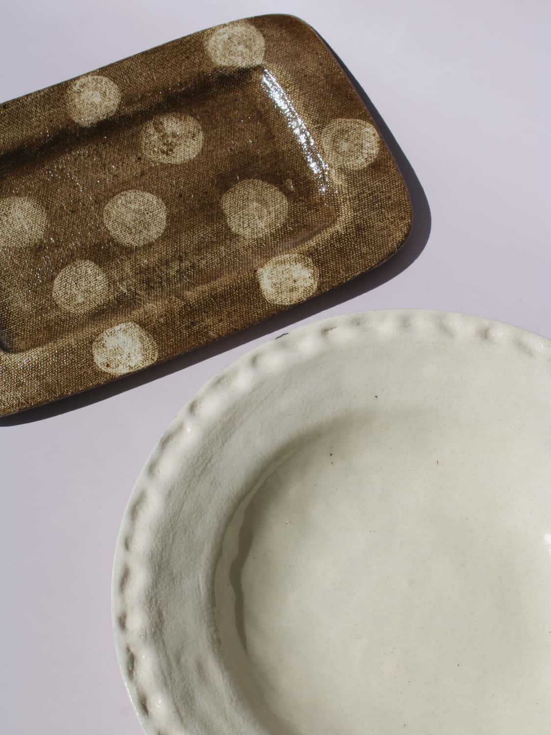 Lunette Ceramic Plate paired with Biscotti Ceramic Plate, cream scalloped plate beside brown polka dot rectangular tray