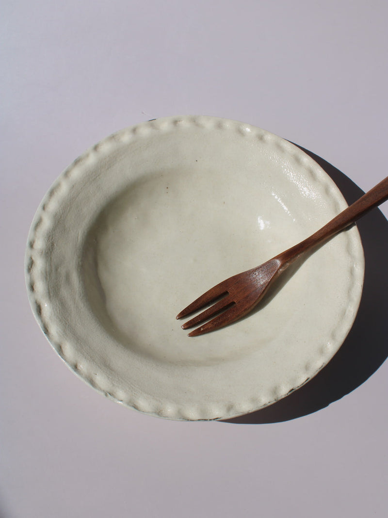 Lunette Ceramic Plate with scalloped beaded edge, styled with a wooden fork, handmade ceramic plate top view