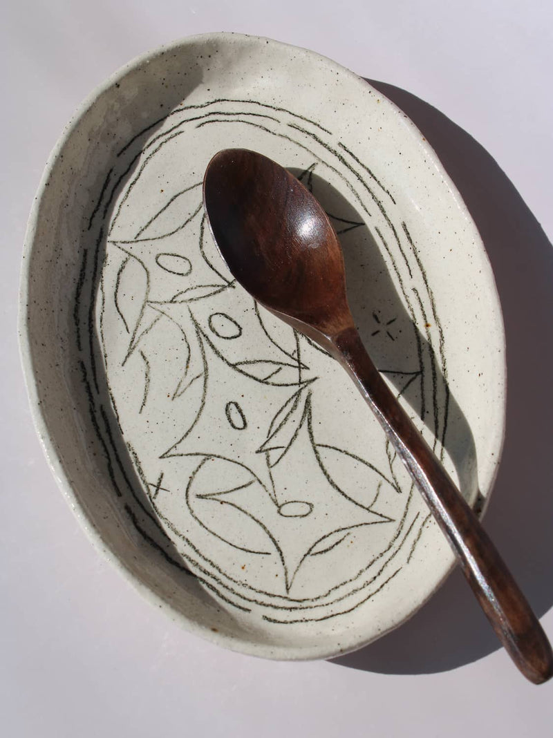 Mythos Ceramic Plate in speckled cream with hand-etched star and leaf motifs, viewed from above on a soft white background.