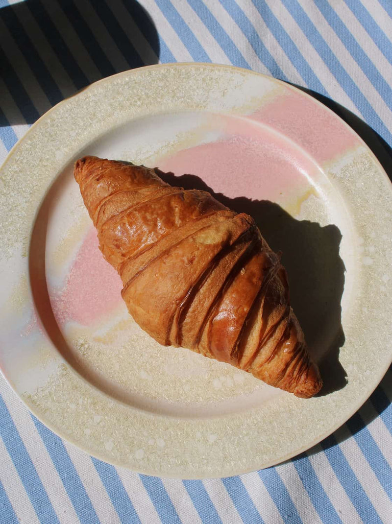 Aurora ceramic plate with soft pink glaze and textured beige rim, modern handmade dinnerware.