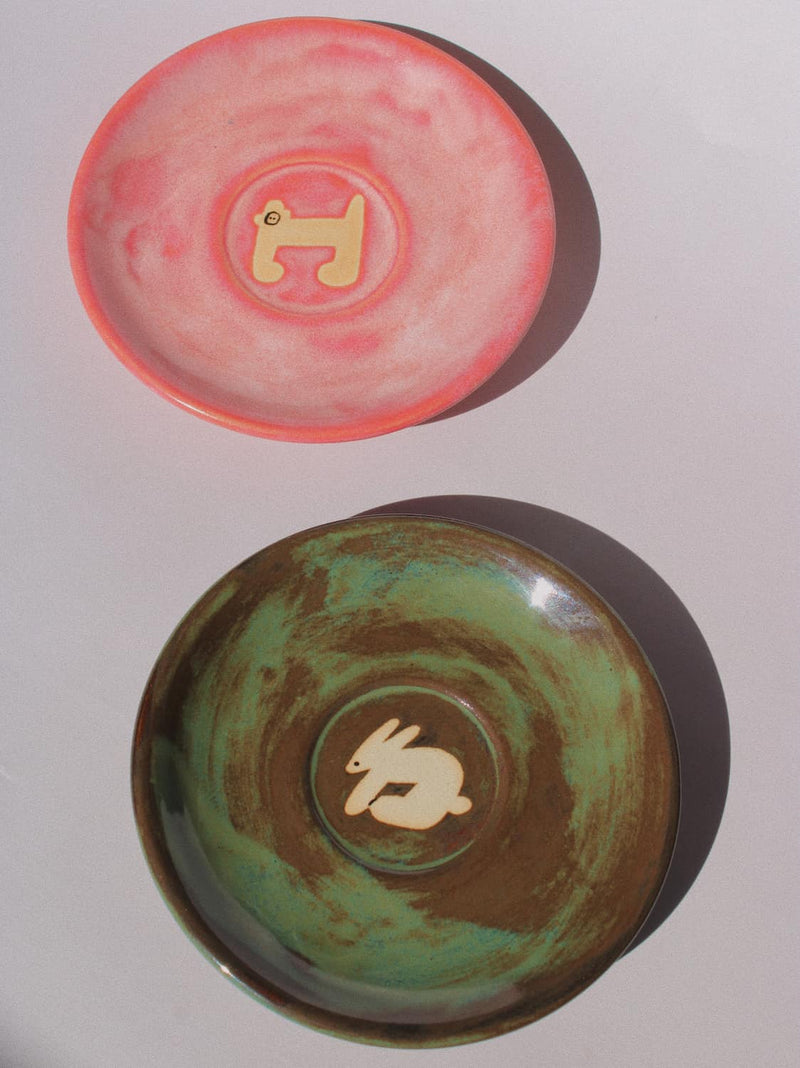 Woodland Rabbit and Candy Monkey Ceramic Plates by Marta Shurpakova – handmade illustrated ceramic plates in earthy green and playful pink tones