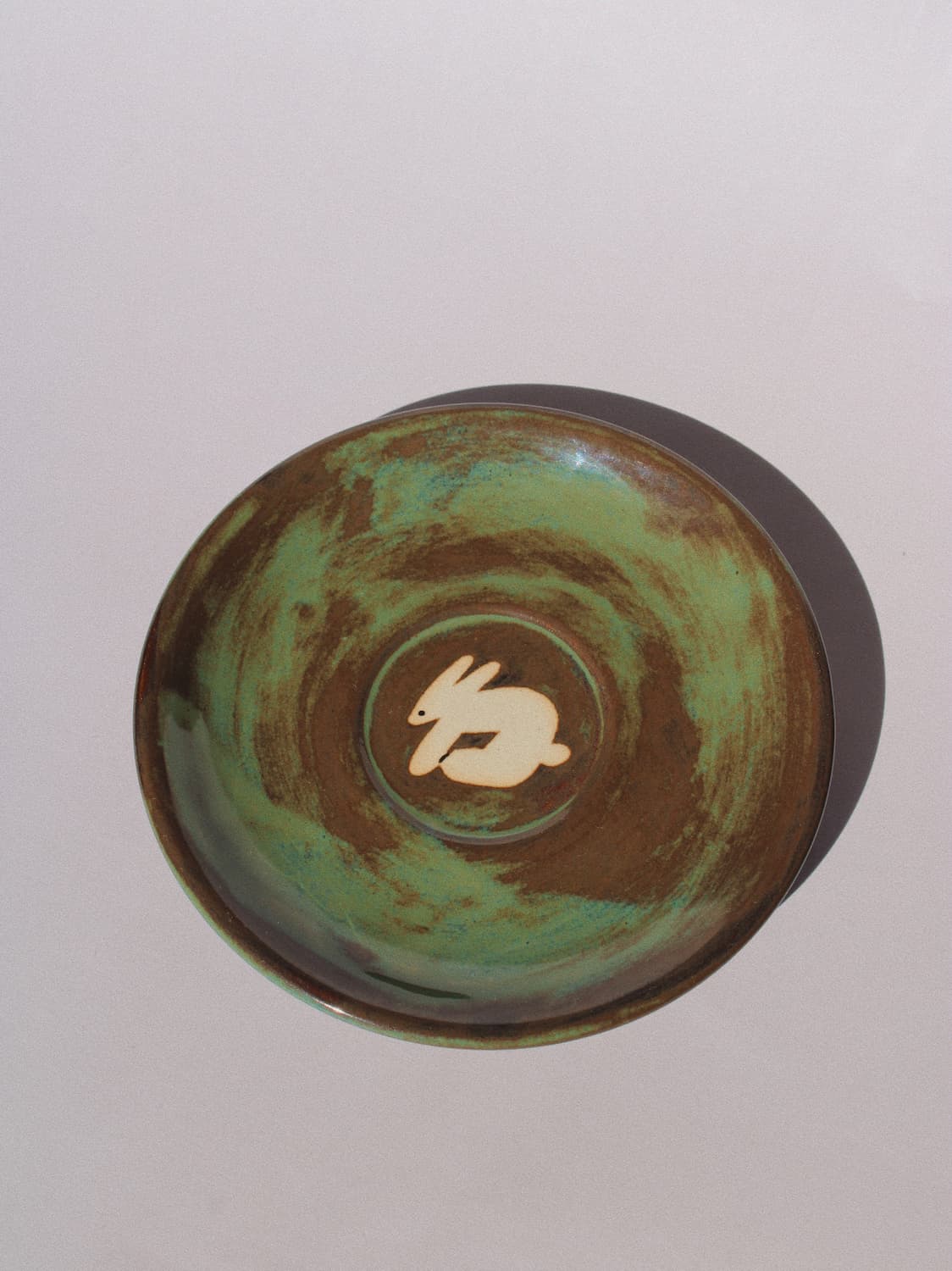 Woodland Rabbit Ceramic Plate by Marta Shurpakova – handmade ceramic plate with an illustrated rabbit and earthy green glaze