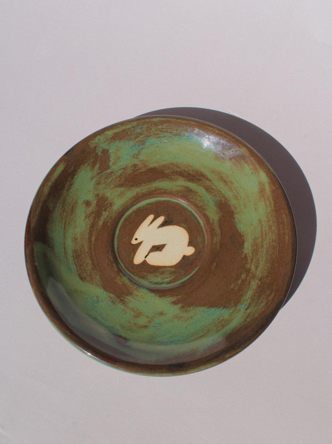 Woodland Rabbit Ceramic Plate by Marta Shurpakova – handmade ceramic plate with an illustrated rabbit and earthy green glaze