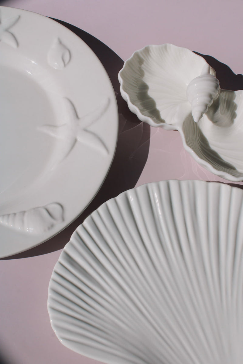 Caspia, Littora and Calista Ceramic Shell pieces from the Ocean Whisper collection, embossed starfish plate, scallop dish with sage accents, and ribbed shell-shaped plate