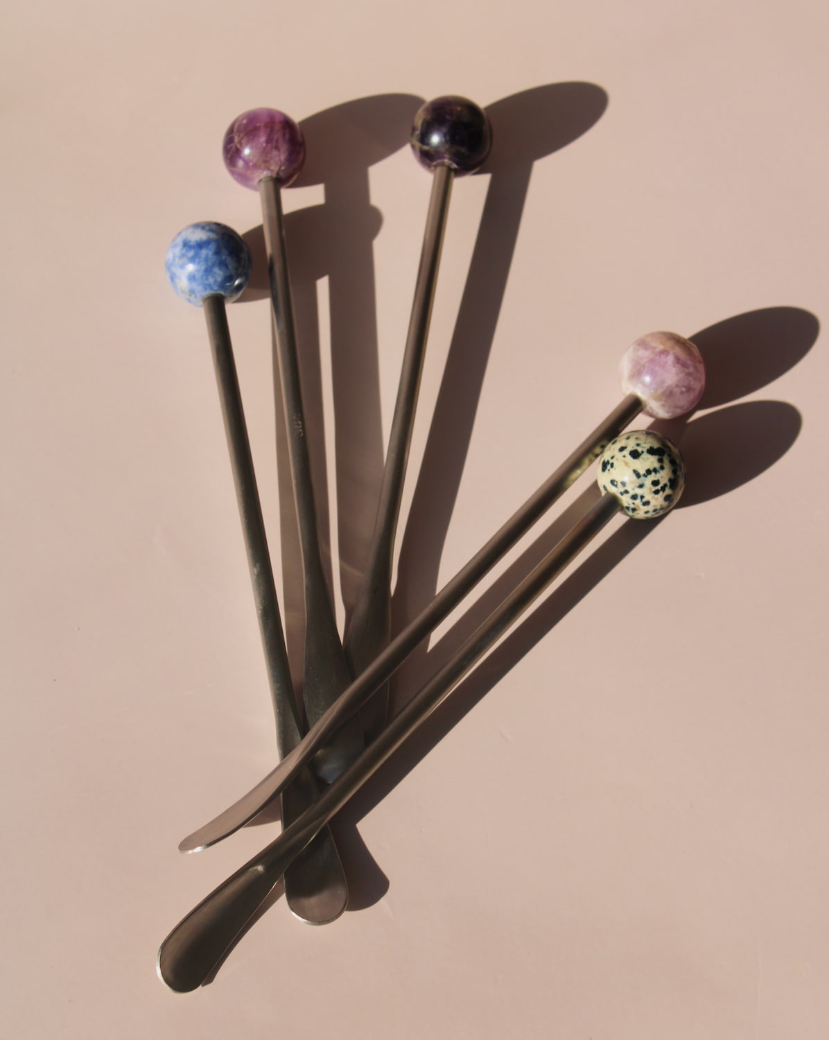Astra Stone Stirrer collection featuring Nebula, Aster, Amethyst, and Ember stone drink stirrers in sculptural barware design.