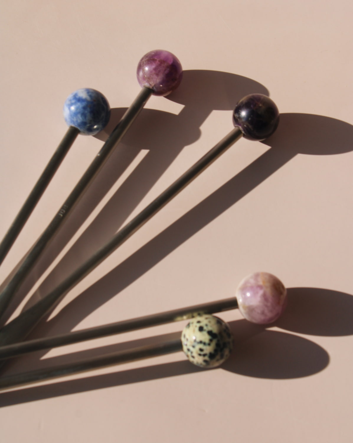 Astra Stone Stirrer collection featuring Nebula, Aster, Amethyst, and Ember stone drink stirrers in sculptural barware design.