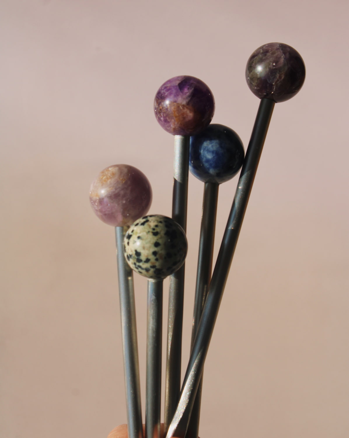 Astra Stone Stirrer collection featuring Nebula, Aster, Amethyst, and Ember stone drink stirrers in sculptural barware design.