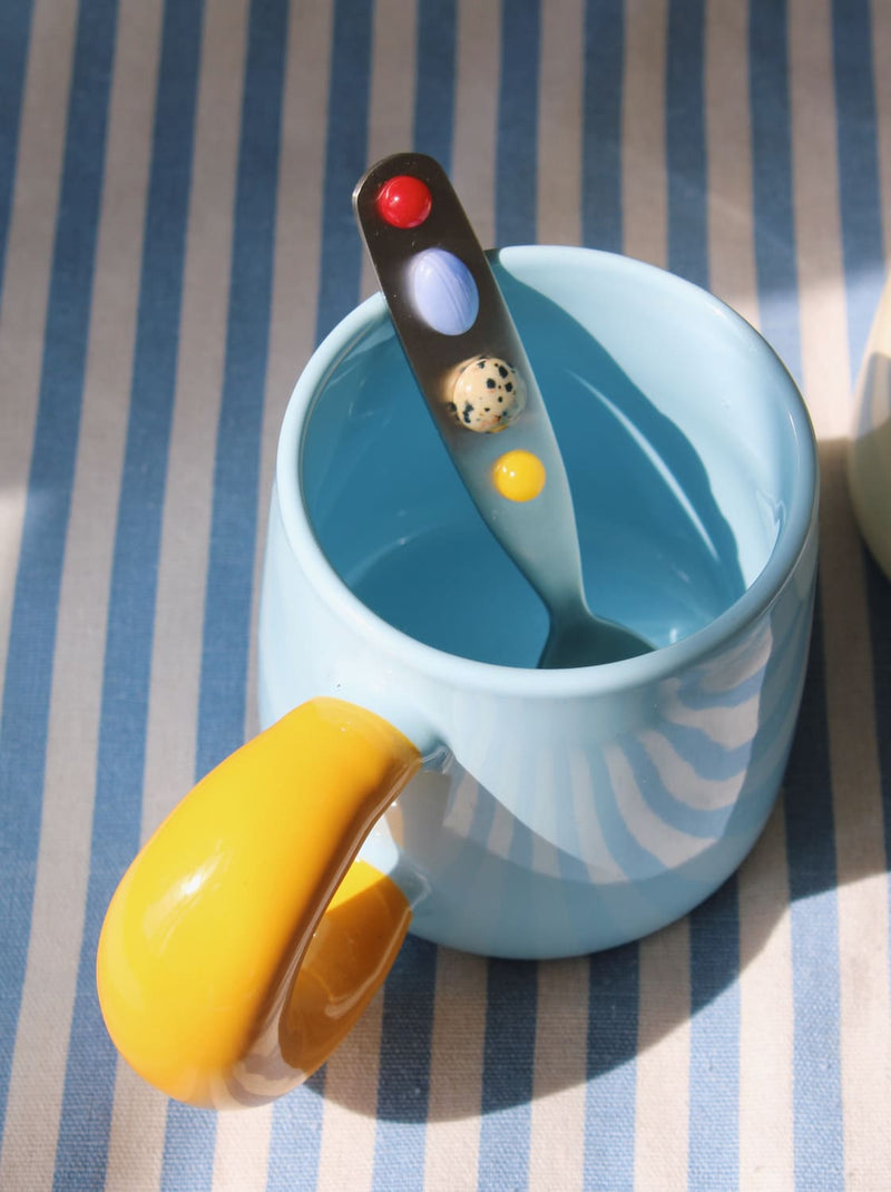 Close-up of Constella spoon with colorful handle in cup.