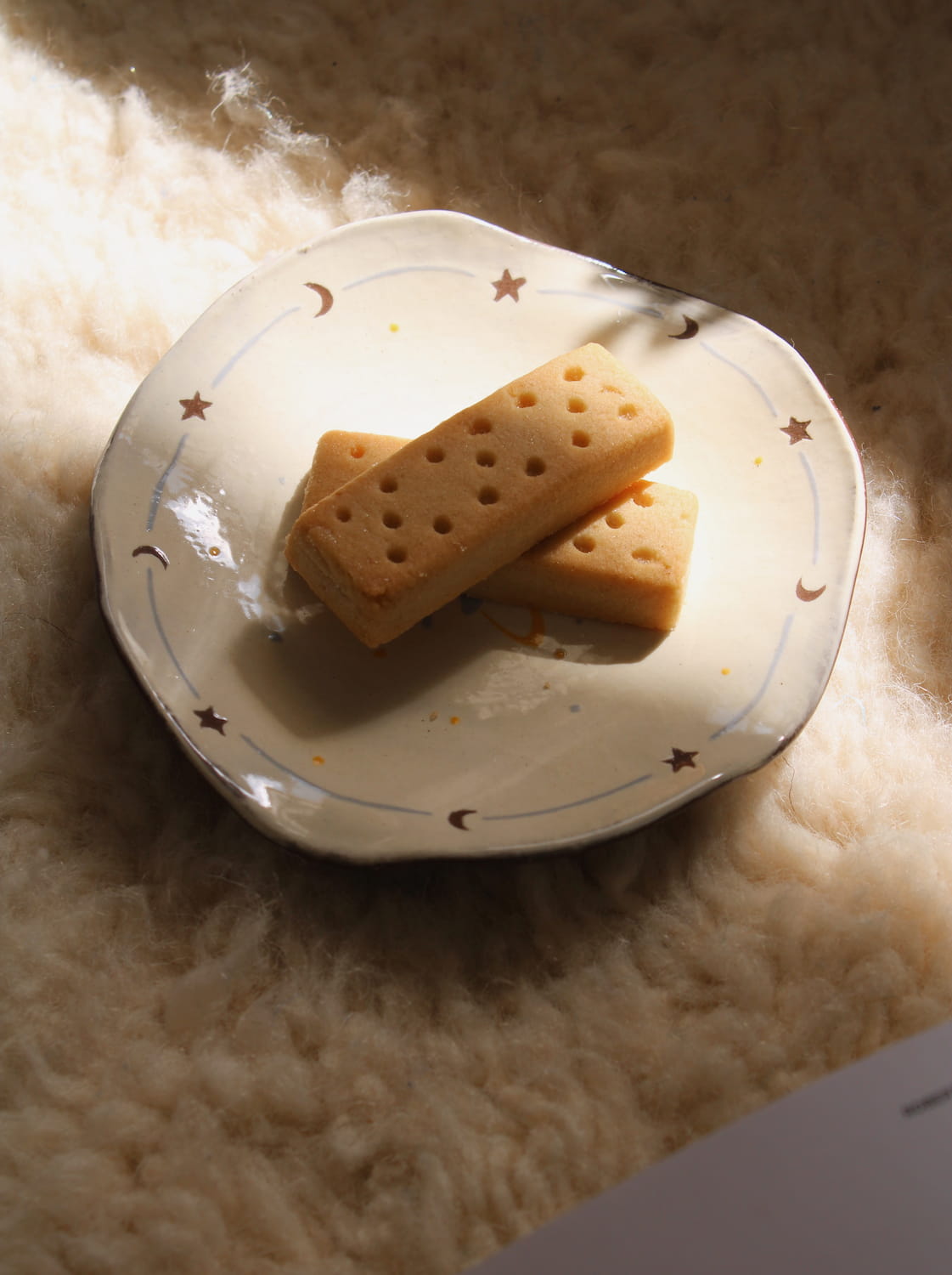 Elio ceramic plate with pastry in warm sunlight creating soft shadows.