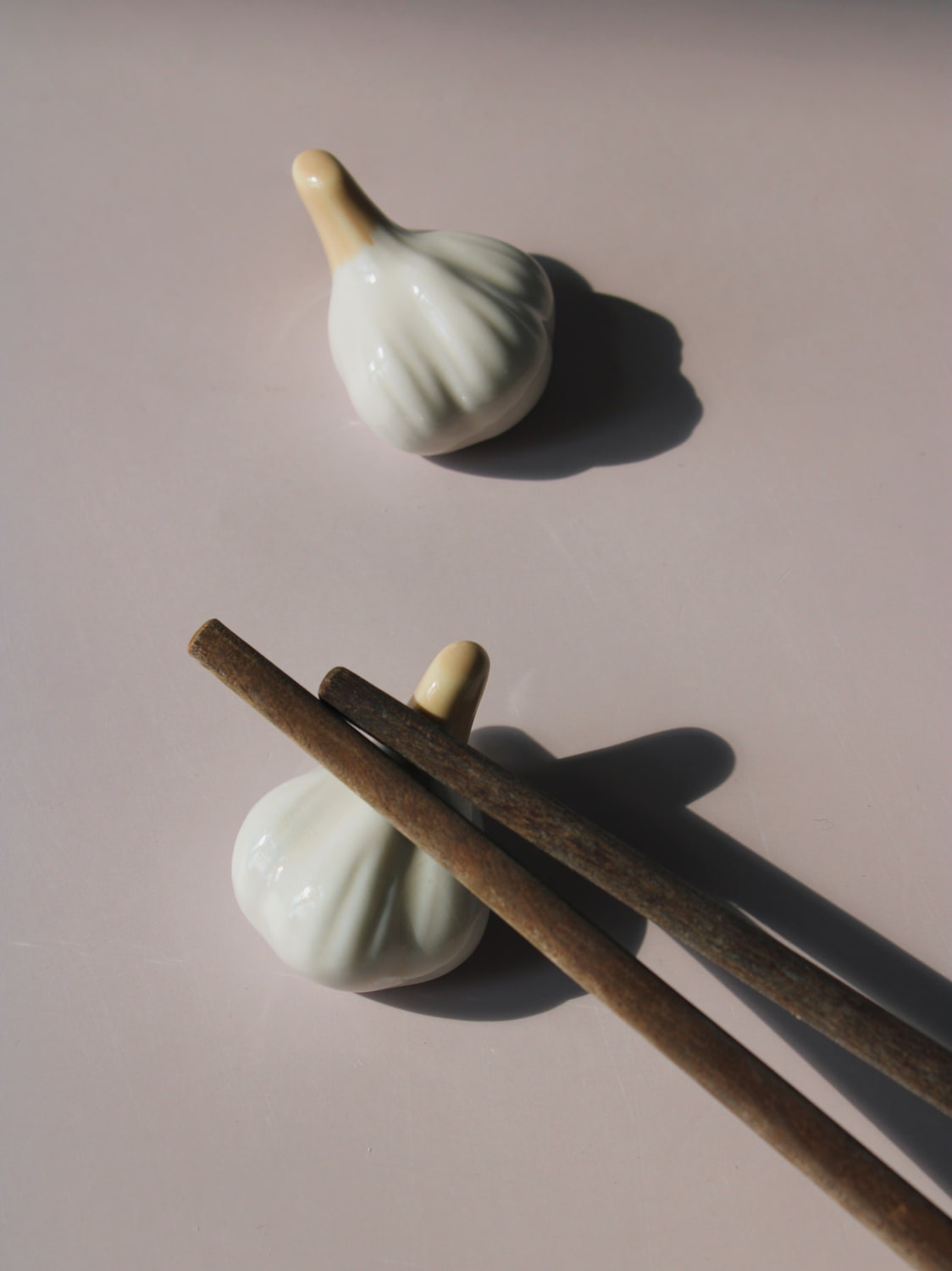Garlic Ceramic Chopstick Rest Set shaped like garlic cloves with golden brown stems, handmade ceramic