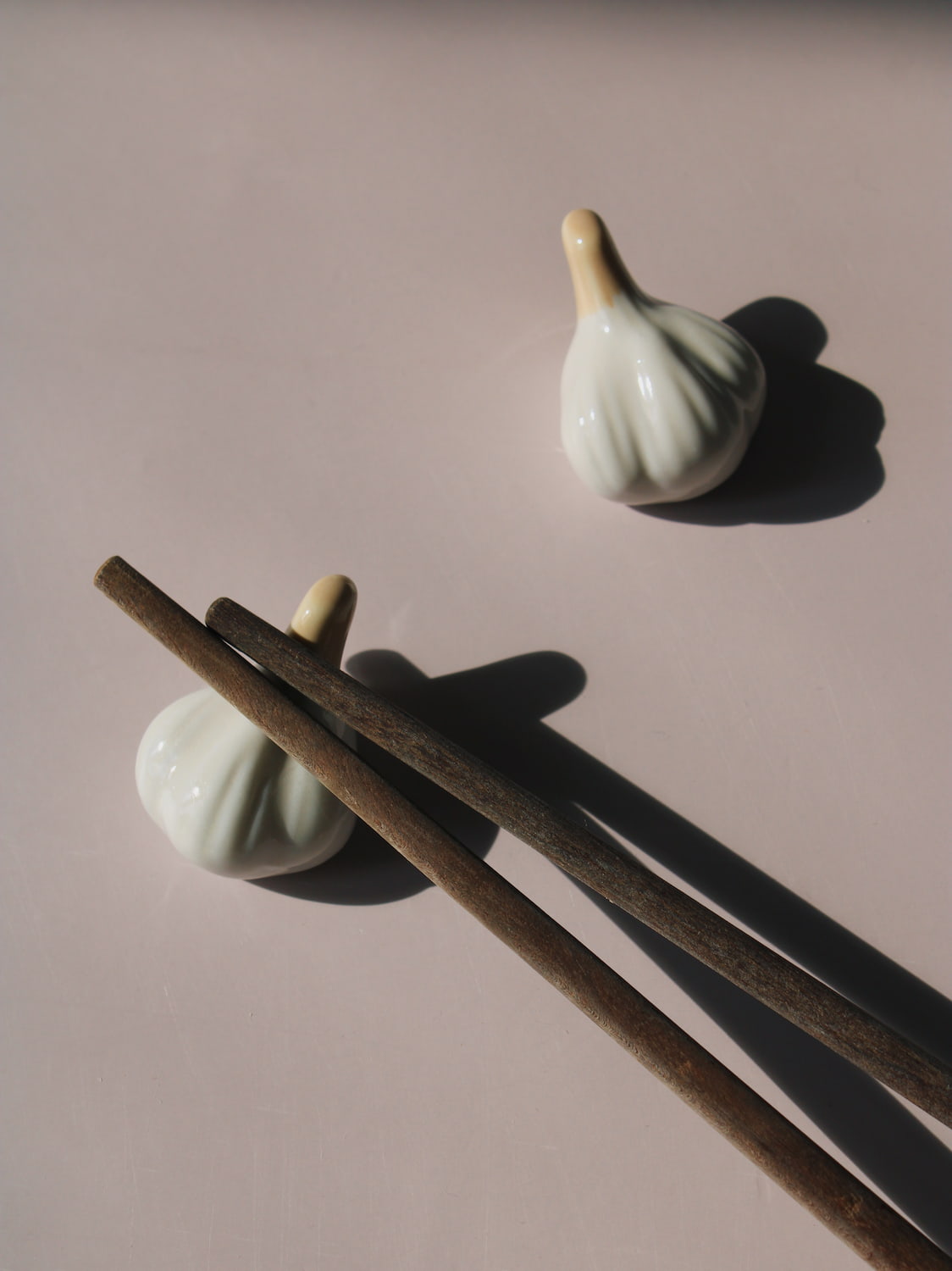 Garlic Ceramic Chopstick Rest Set shaped like garlic cloves with golden brown stems, handmade ceramic