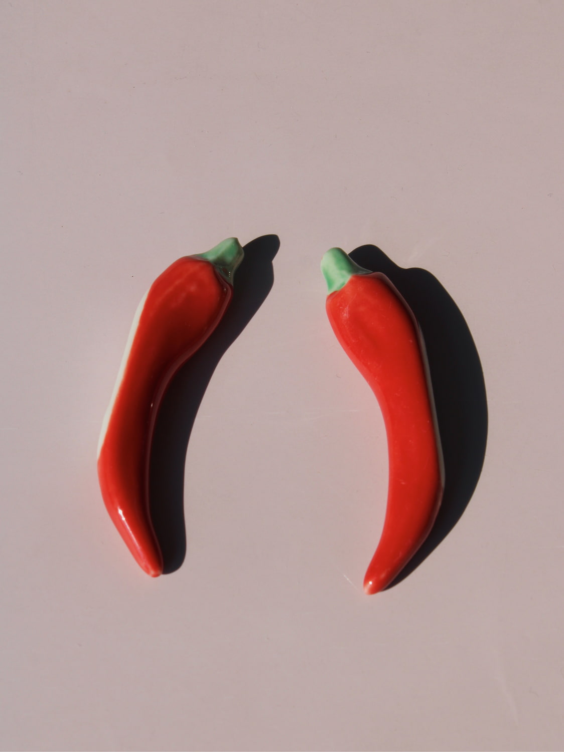 Chili Ceramic Chopstick Rest Set in red chili pepper shape with green stem, styled with a wooden fork, handmade ceramic