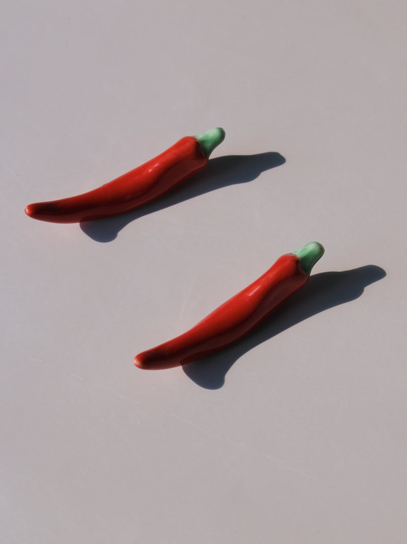 Chili Ceramic Chopstick Rest Set in red chili pepper shape with green stem, styled with a wooden fork, handmade ceramic