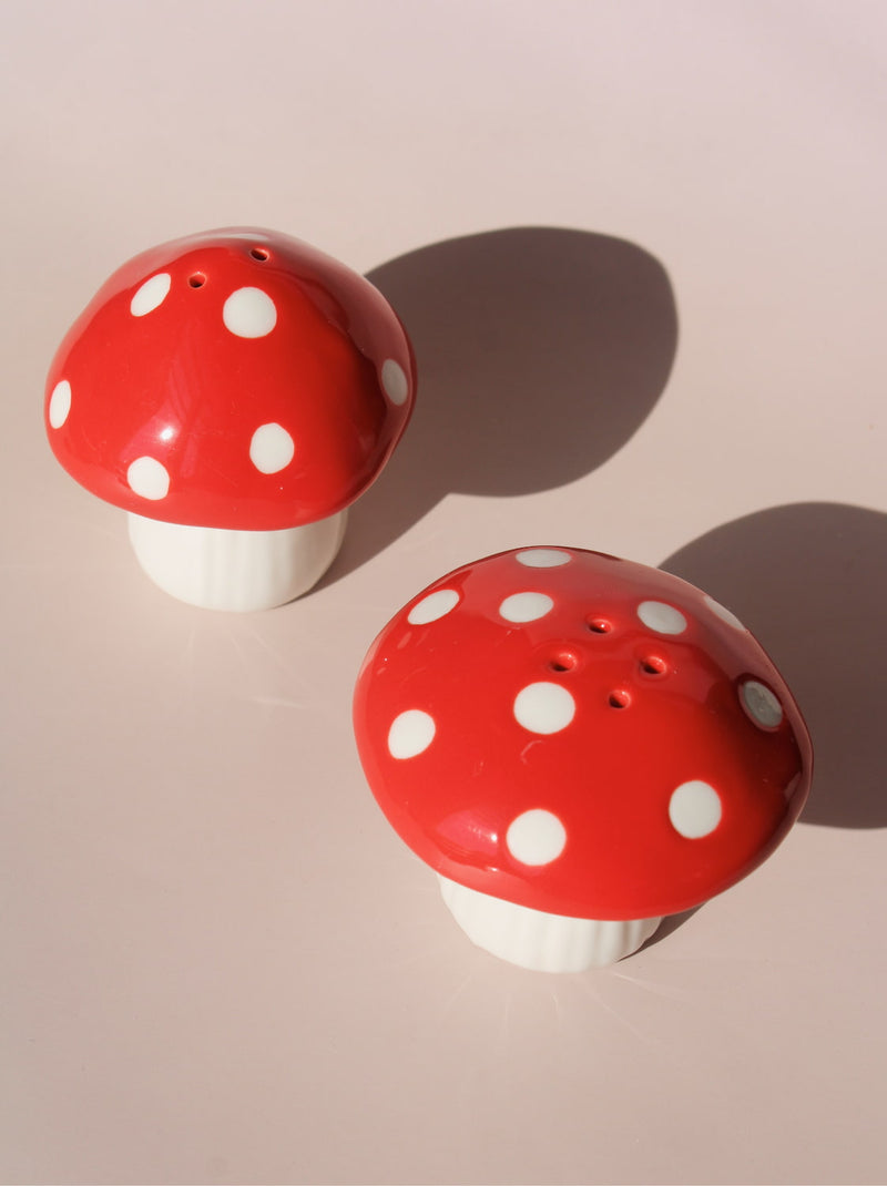 Red mushroom salt and pepper shakers with white polka dots in glossy ceramic finish.