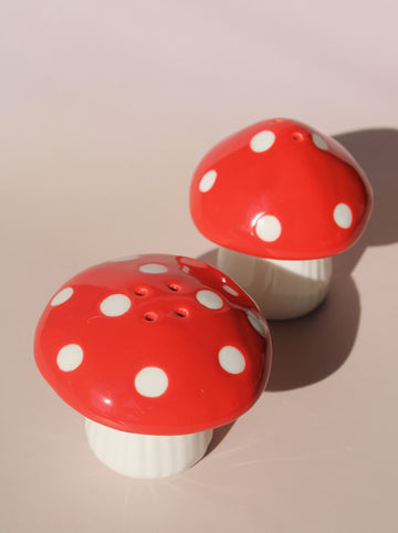 Red mushroom salt and pepper shakers with white polka dots in glossy ceramic finish.