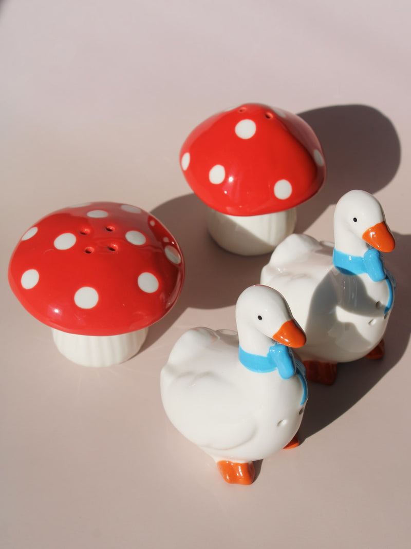 Ceramic duck and red mushroom salt and pepper shakers with playful vintage-inspired design.