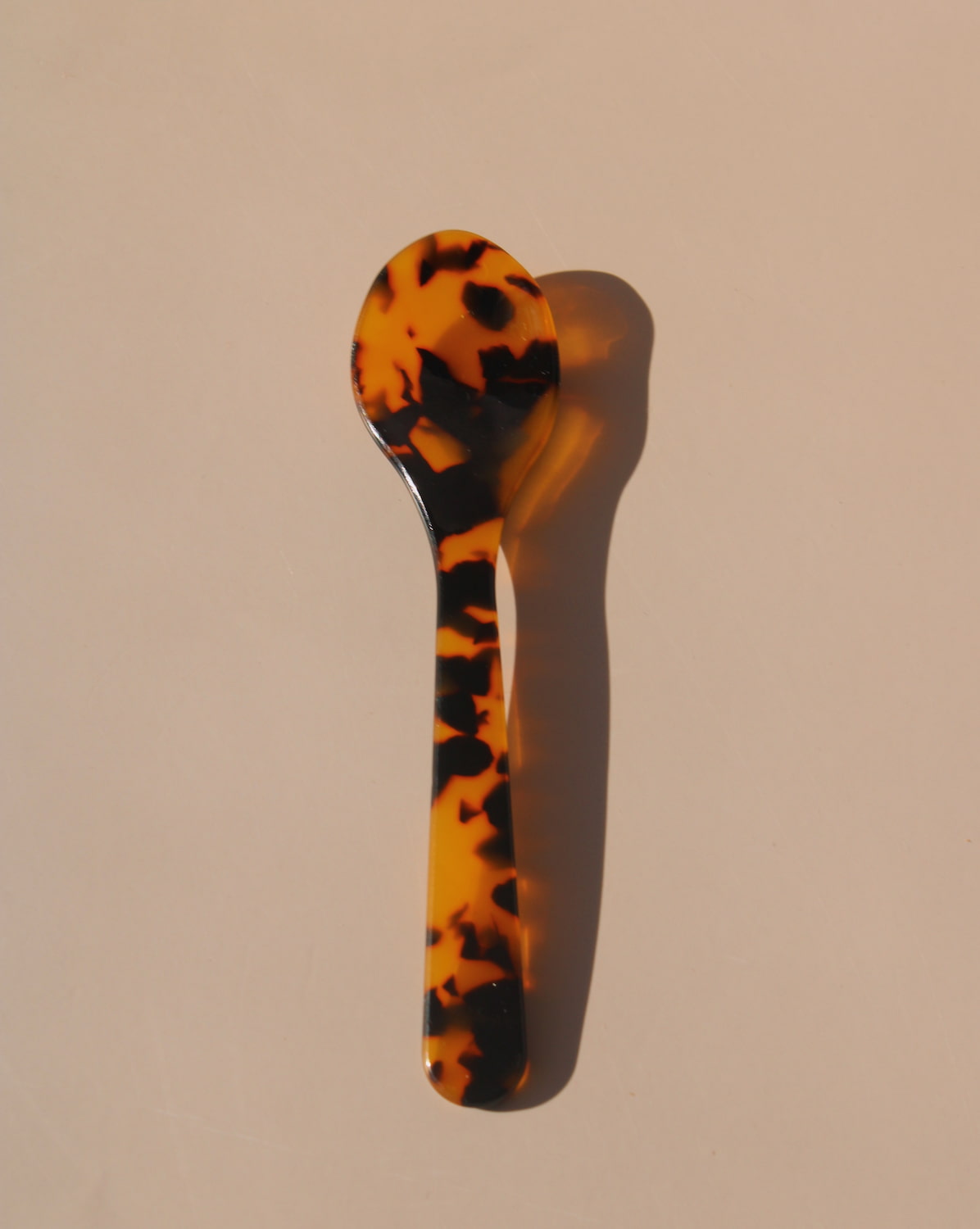 Tortoiseshell resin spoons with glossy finish, modern acrylic dessert spoons.