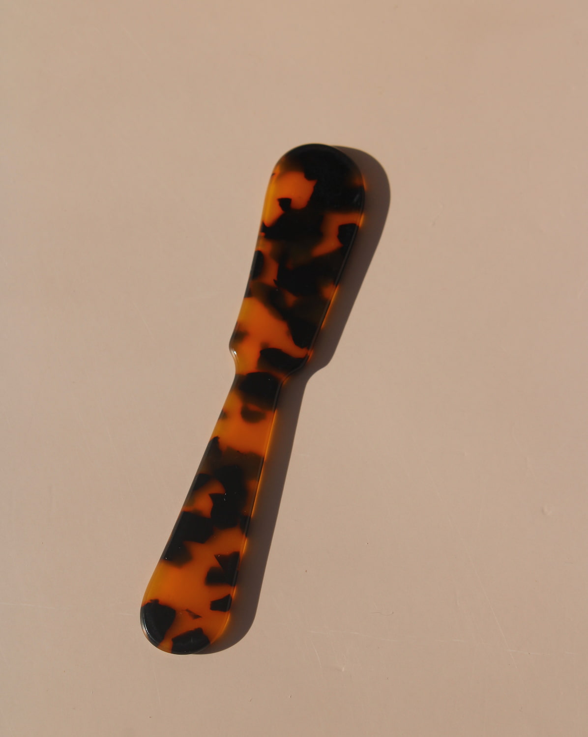 Tortoiseshell resin spoons with glossy finish, modern acrylic dessert spoons.