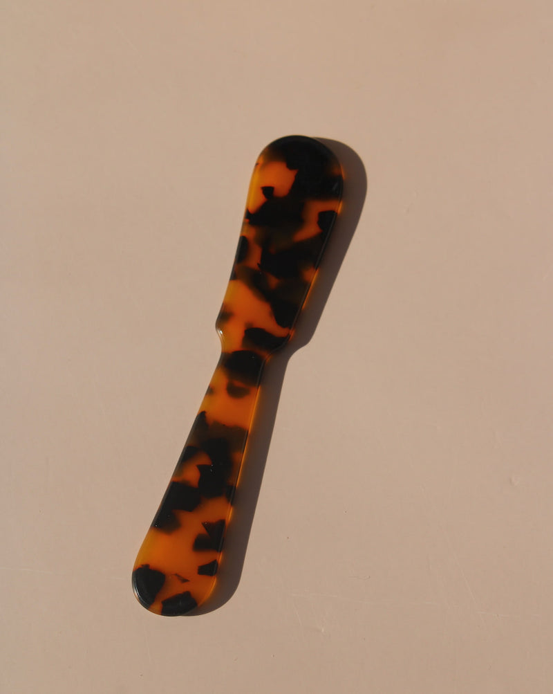 Tortoiseshell resin spoons with glossy finish, modern acrylic dessert spoons.
