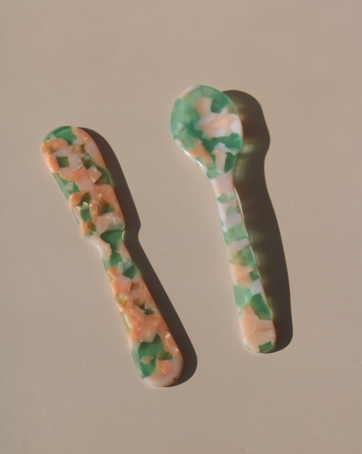 Green and peach marbled acrylic spoons, handmade-look resin dessert spoons for stylish table settings.