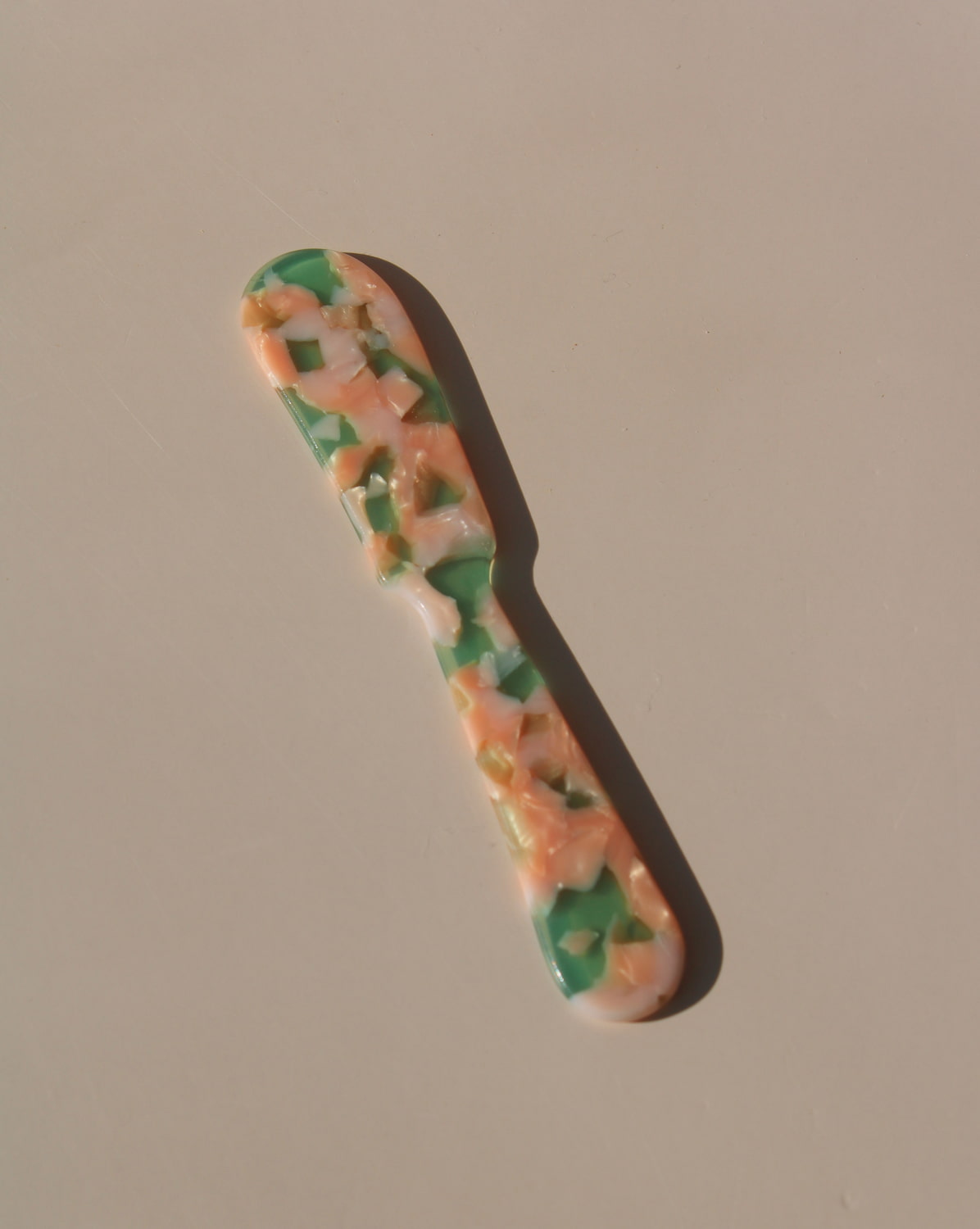 Green and peach marbled acrylic spoons, handmade-look resin dessert spoons for stylish table settings.