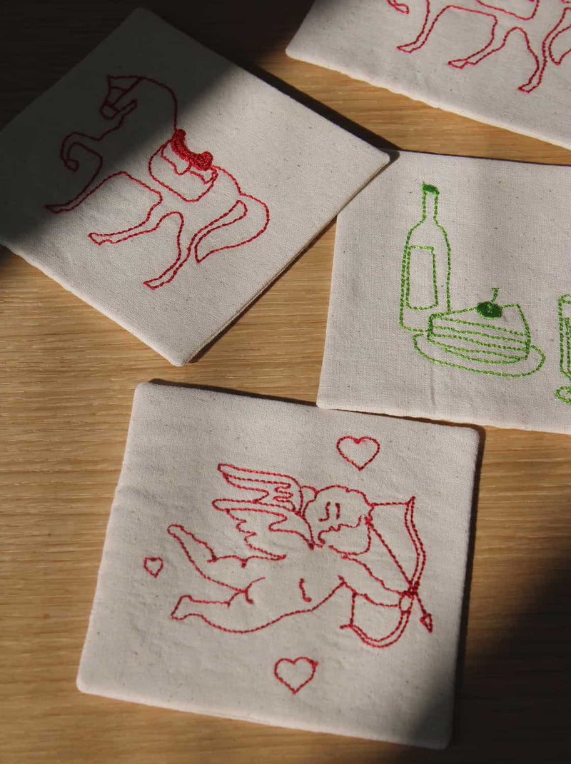 Cavalier, Maison, and Amour Handsewn Embroidered Coasters with horse, wine, and cupid motifs stitched on natural cotton handmade drink coasters.