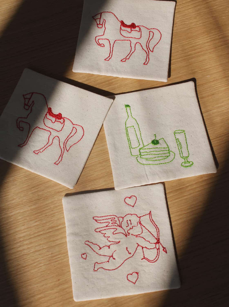 Cavalier, Maison, and Amour Handsewn Embroidered Coasters with horse, wine, and cupid motifs stitched on natural cotton handmade drink coasters.
