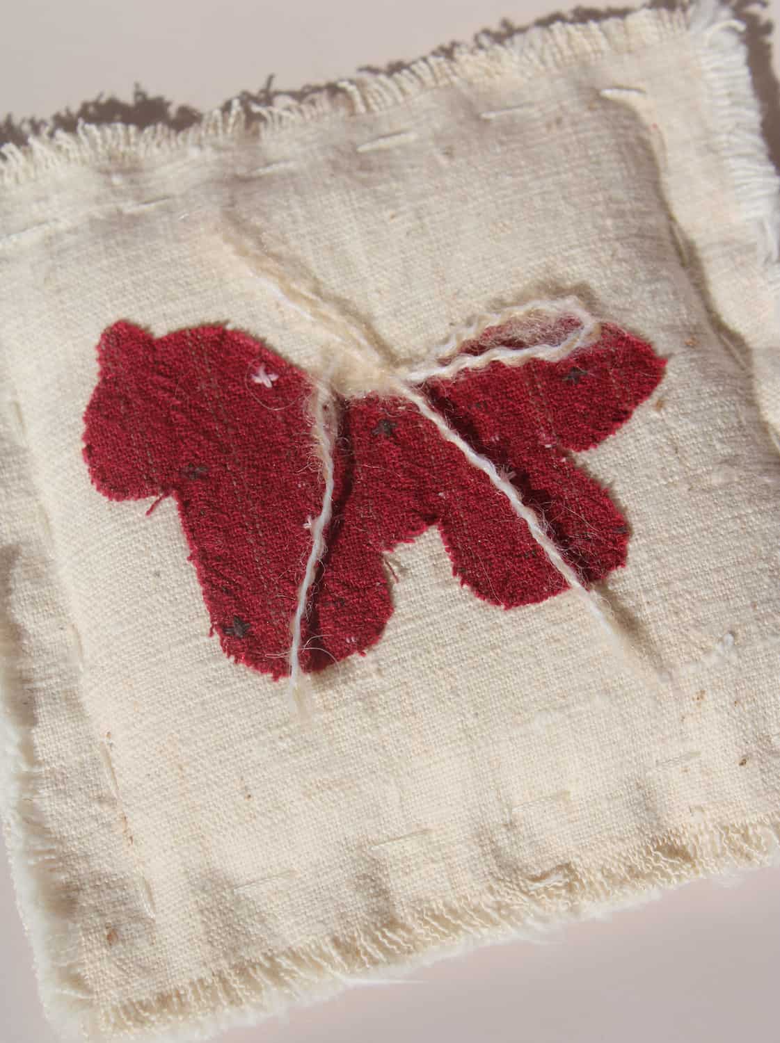 Écurie handmade horse coaster with red embroidered horse design on natural cotton fabric, hand-sewn textile coaster.