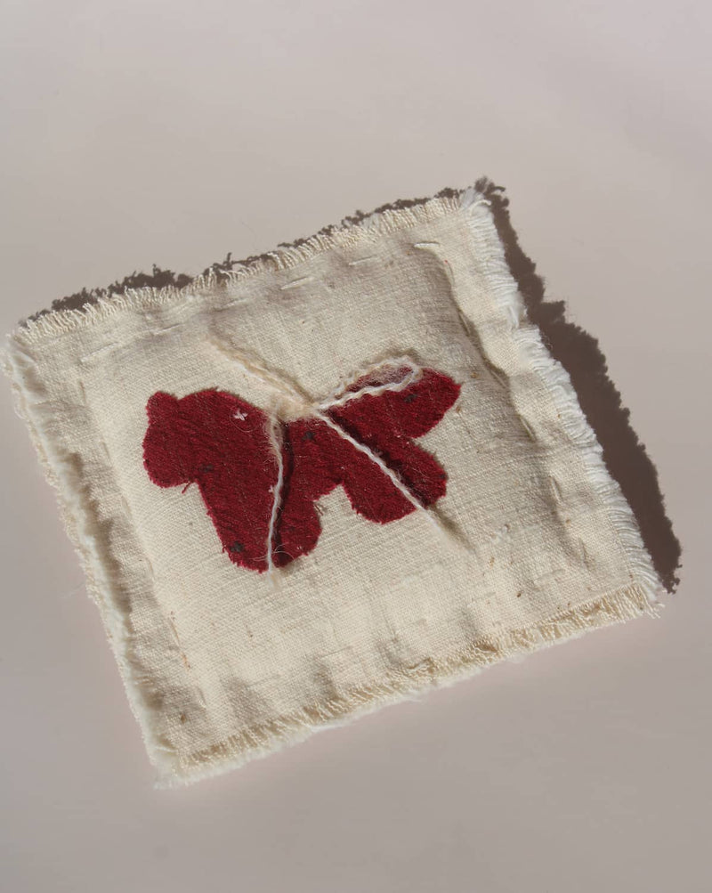 Écurie handmade horse coaster with red embroidered horse design on natural cotton fabric, hand-sewn textile coaster.
