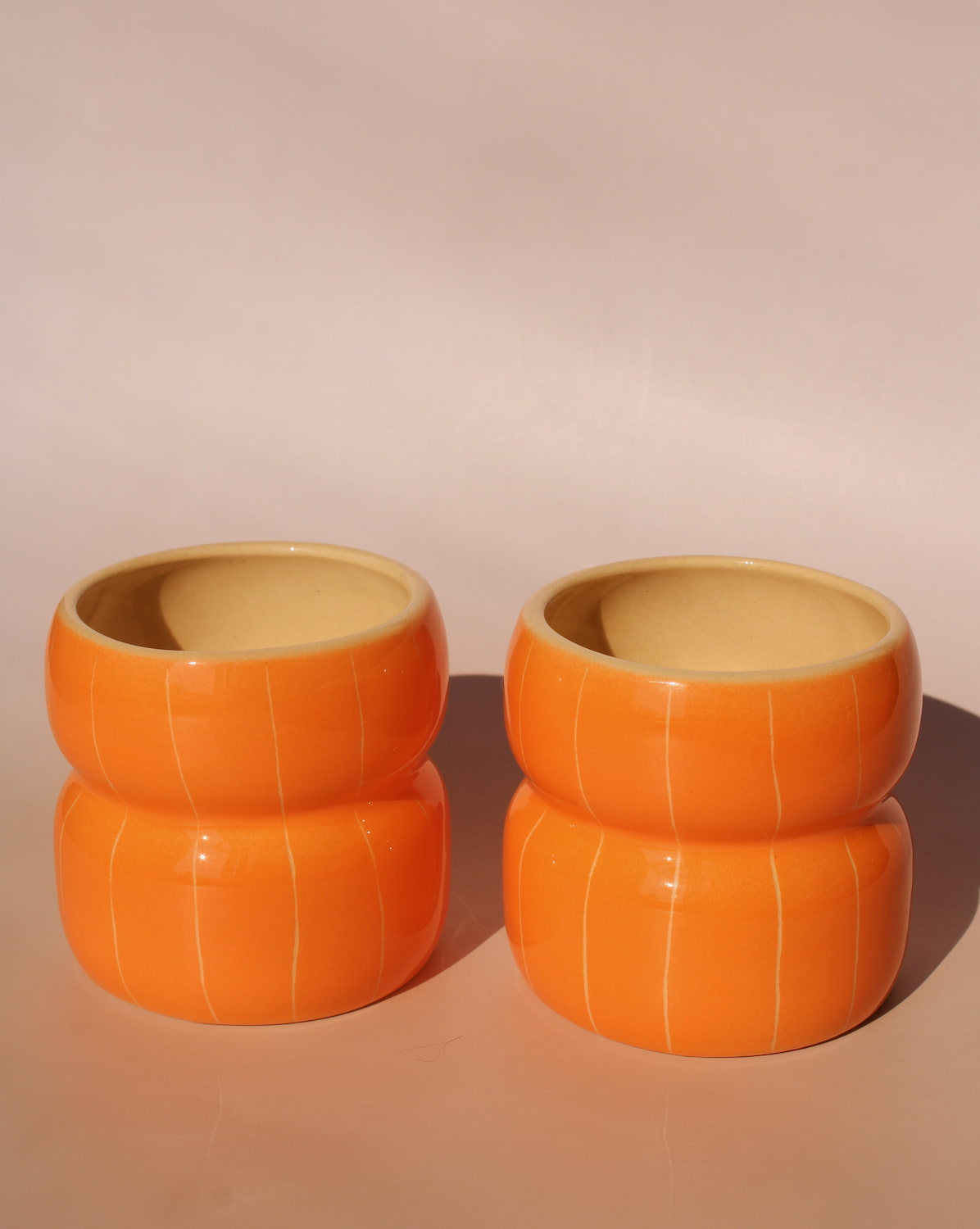 two Belly Tangerine ceramic mugs by Agata Puławska handmade orange coffee cups