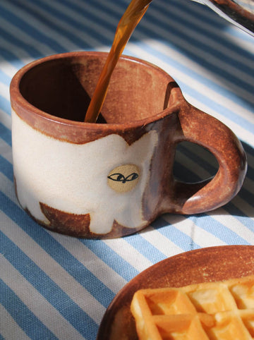 Handmade Chestnut mug with rich earthy tones and coffee being poured in natural light