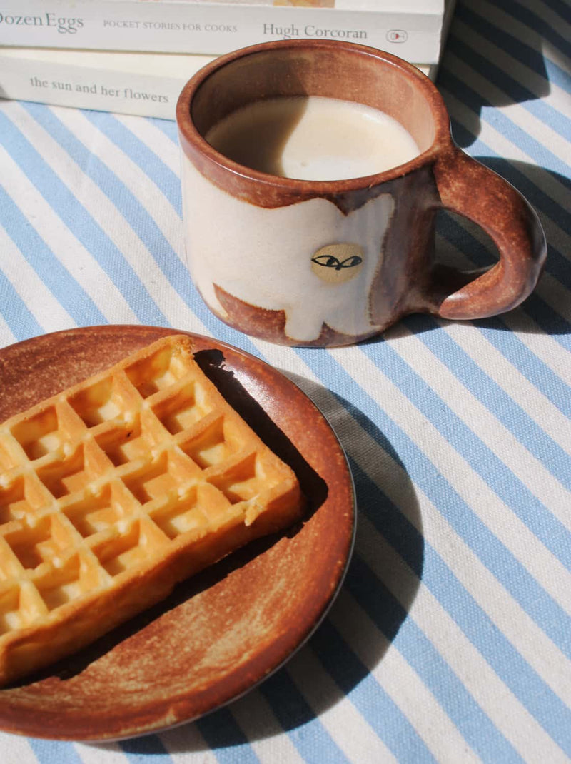Handmade Chestnut mug with rich earthy tones and coffee being poured in natural light