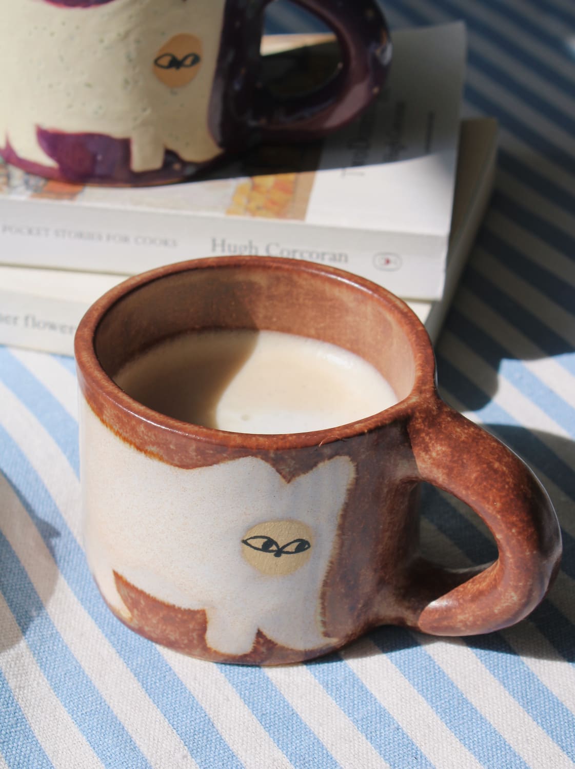 Handmade Chestnut mug with rich earthy tones and coffee being poured in natural light