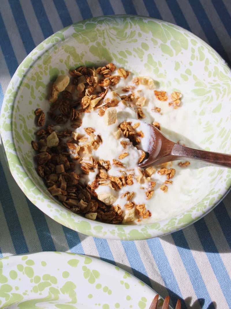 Yogurt clover enamel bowl with granola on a striped tablecloth