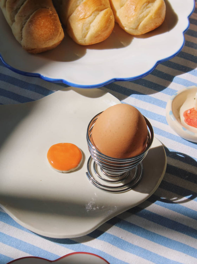 Ceramic egg spoon rest styled on a breakfast table, a small detail that makes slow mornings feel more considered.