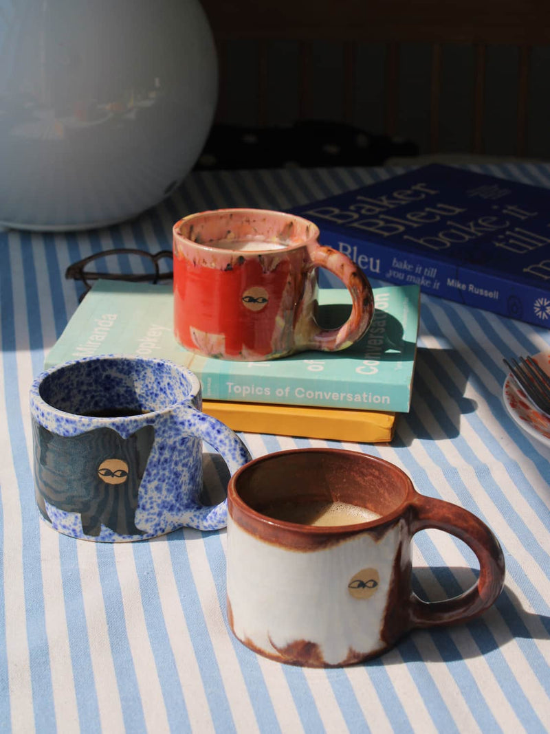 Handmade ceramic cat mugs by Marta Shurpakova – three colourful illustrated mugs in different designs and glazes