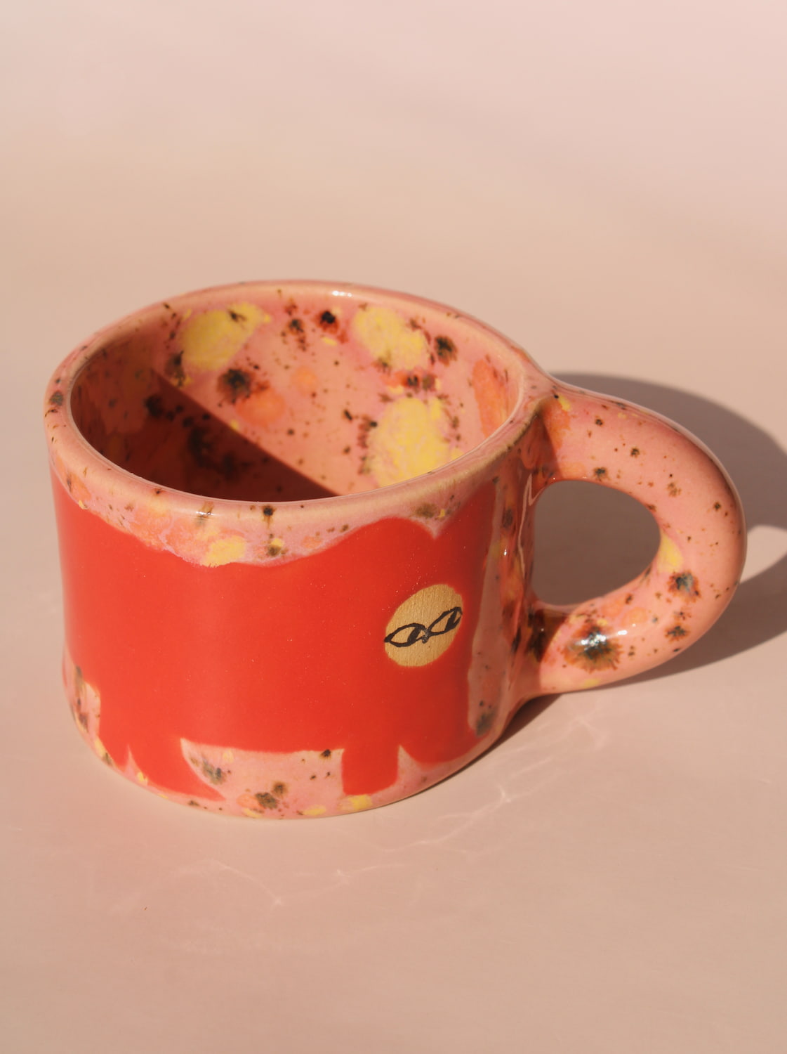 Ceramic mug with a red design on a beige background