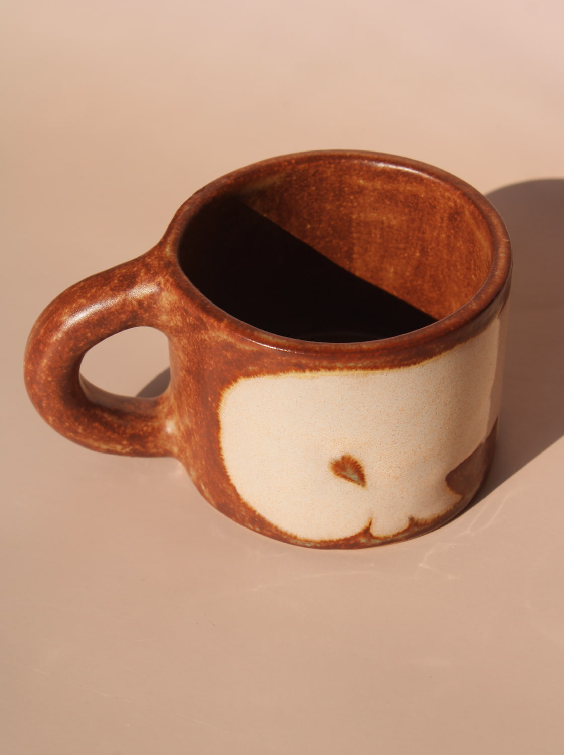Brown ceramic mug on a beige background