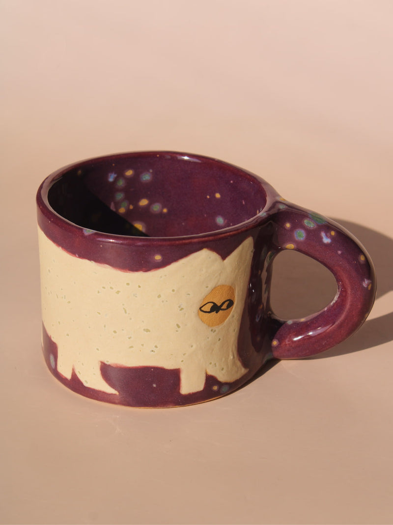 Ceramic mug with a purple rim and handle on a beige background