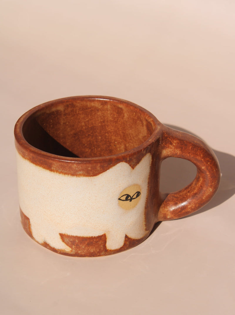 Ceramic mug with a cat design on a beige background