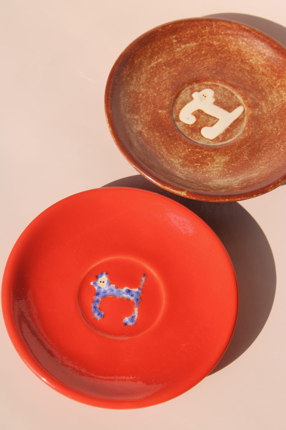 two handmade ceramic monkey plates by Marta Shurpakova artisan dessert plates in different glaze colors