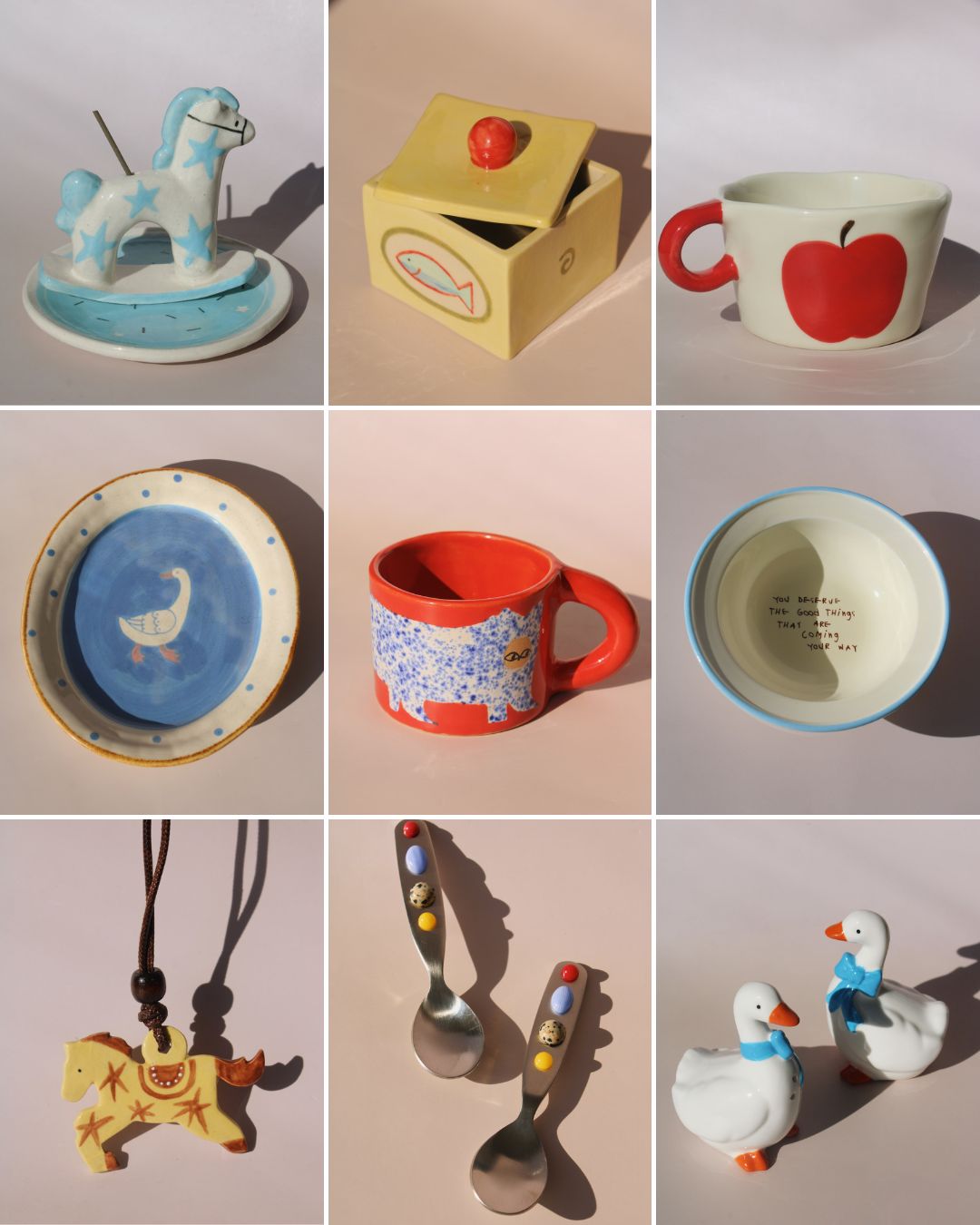 Collection of ceramic items including a rocking horse, box, mugs, and other decorative pieces on a light pink background.