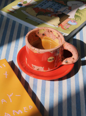 Poppy ceramic mug with warm-toned glaze and coffee, styled with book and soft light for relaxed morning ritual