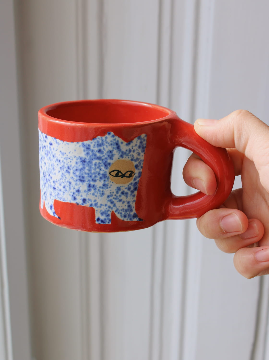 Scarlet ceramic cat mug with hand-painted blue cat illustration and red handle